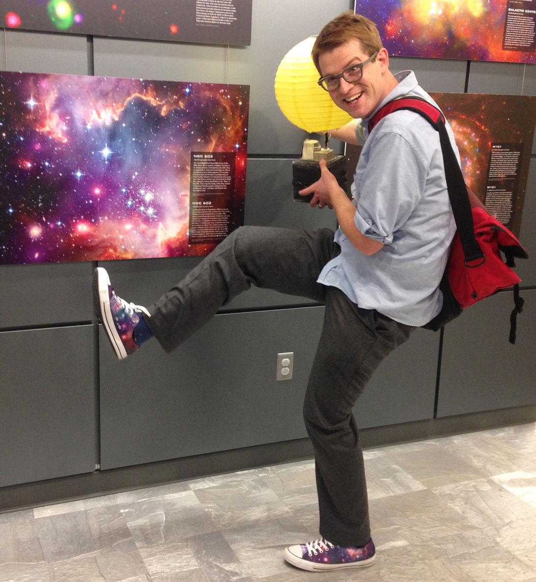 goofy photo of Zach finding that his shoes match a printed Hubble image of NGC 602 that he found on a planetarium wall